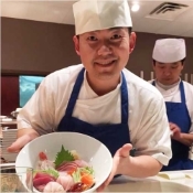 Sushi chief with bowl of sashimi.